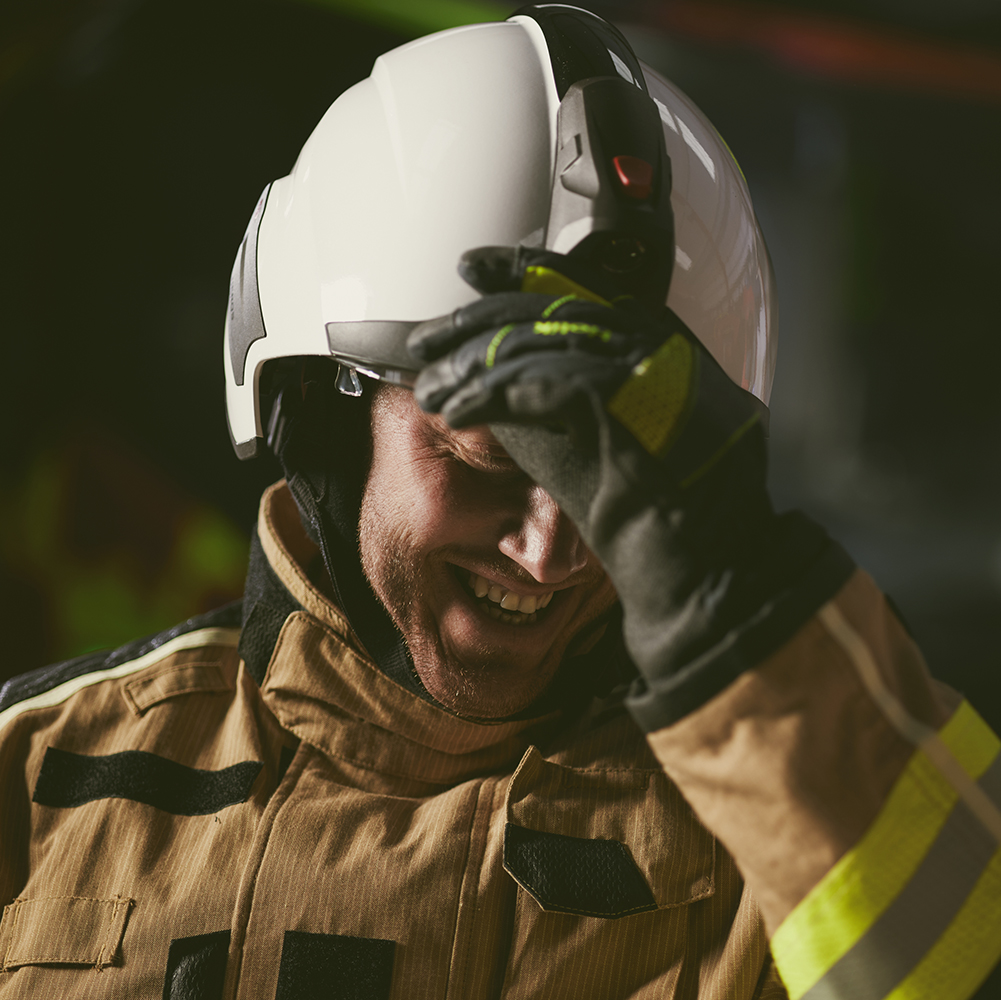 A FlamePro firefighter smiling wearing a helmet - image